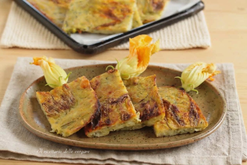 Schiacciata di zucchine e fiori di zucca croccante tagliata a fette su un piatto