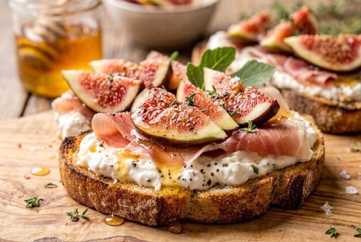 Primo piano ravvicinato di una bruschetta gourmet con fichi freschi, prosciutto crudo e miele.