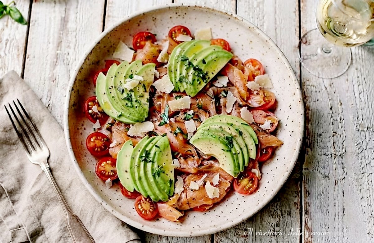 Insalata ricca con salmone affumicato, fettine di avocado, pomodorini e scaglie di parmigiano