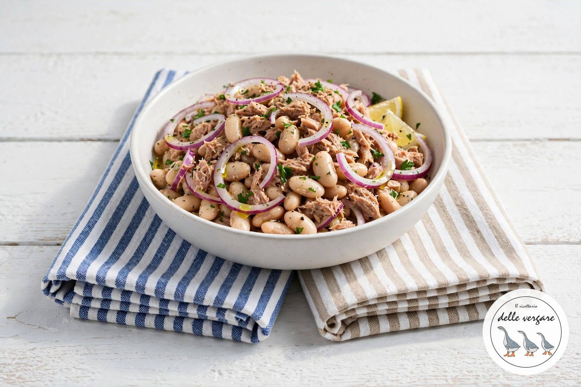 Insalata estiva di fagioli cannellini, tonno e cipolla rossa in una ciotola bianca