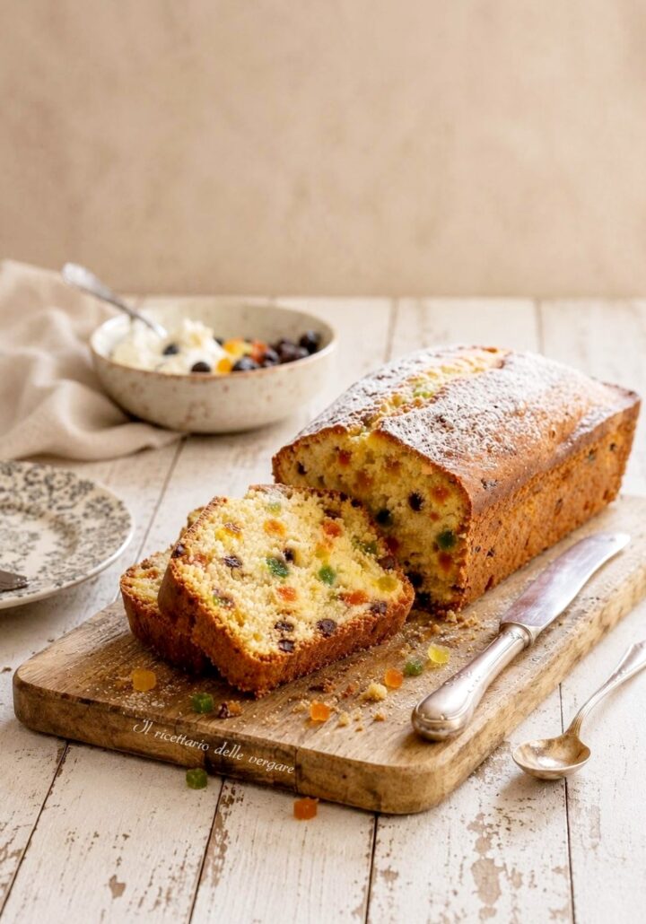 Fetta di plumcake alla ricotta con canditi, gocce di cioccolato e zucchero a velo.