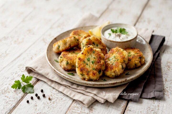 Polpette sfiziose di fagioli cannellini e patate disposte su un piatto con salsa bianca di accompagnamento