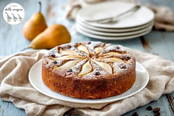 Torta soffice alle pere e cioccolato decorata con fette a raggiera e zucchero a velo.