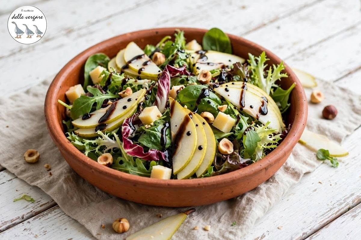 Insalata autunnale con pere a fette, cubetti di taleggio, nocciole tostate e glassa di aceto balsamico.