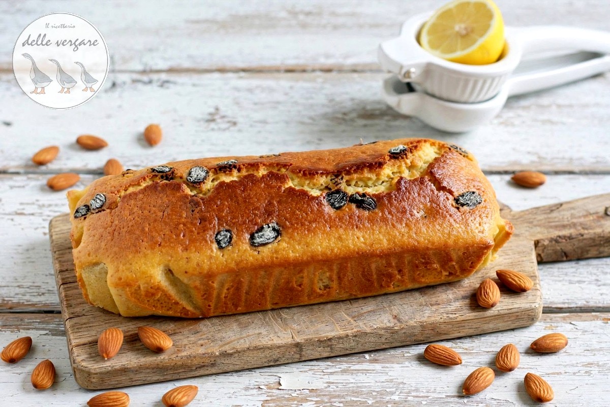 Plumcake soffice allo yogurt con farina di mandorle e uvetta su un tagliere di legno