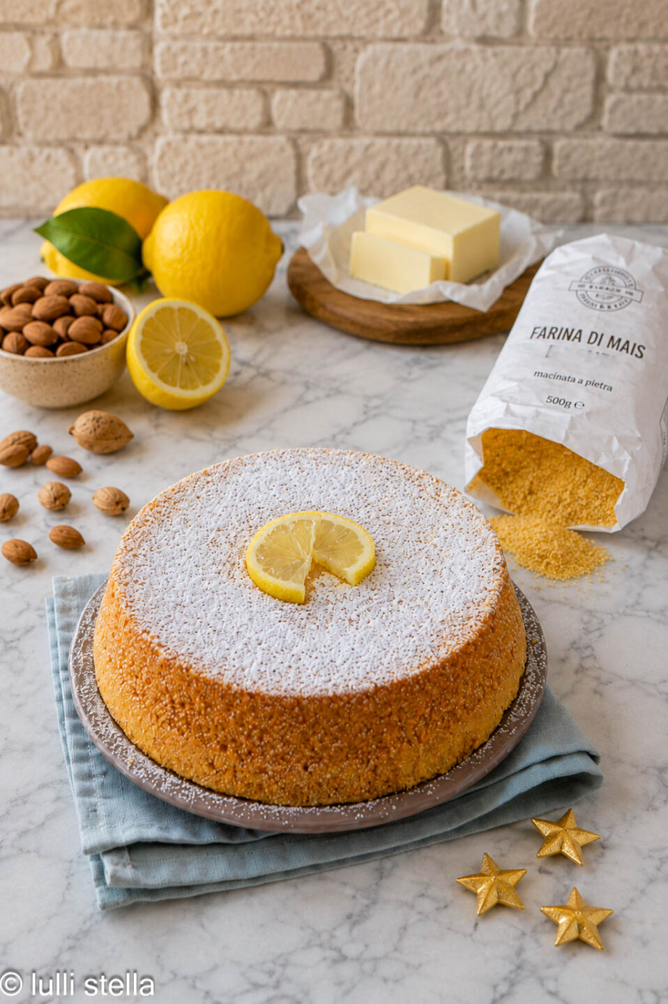 Torta di polenta al limone senza glutine su base effetto marmo con limoni freschi