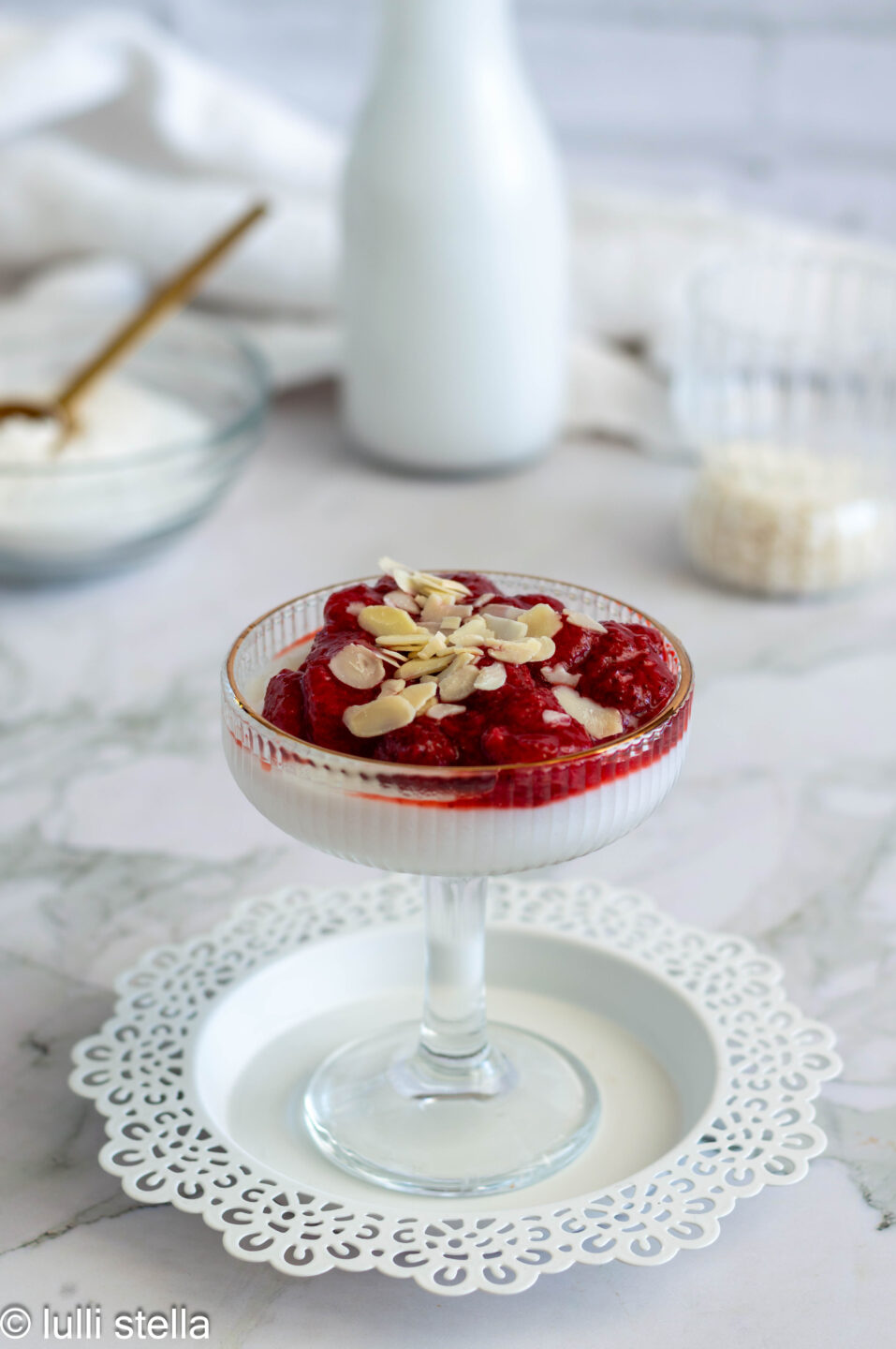 Crema di riso senza glutine servita in una coppa con frutta fresca e crema di mandorle