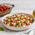 Dettaglio dell'insalata con formaggio di capra fresco, pomodorini e olive condita con olio extravergine di oliva