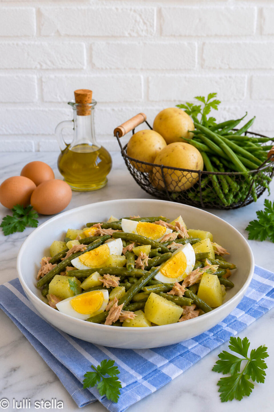 Insalata di patate con fagiolini, tonno e uova sode servita come piatto unico estivo.