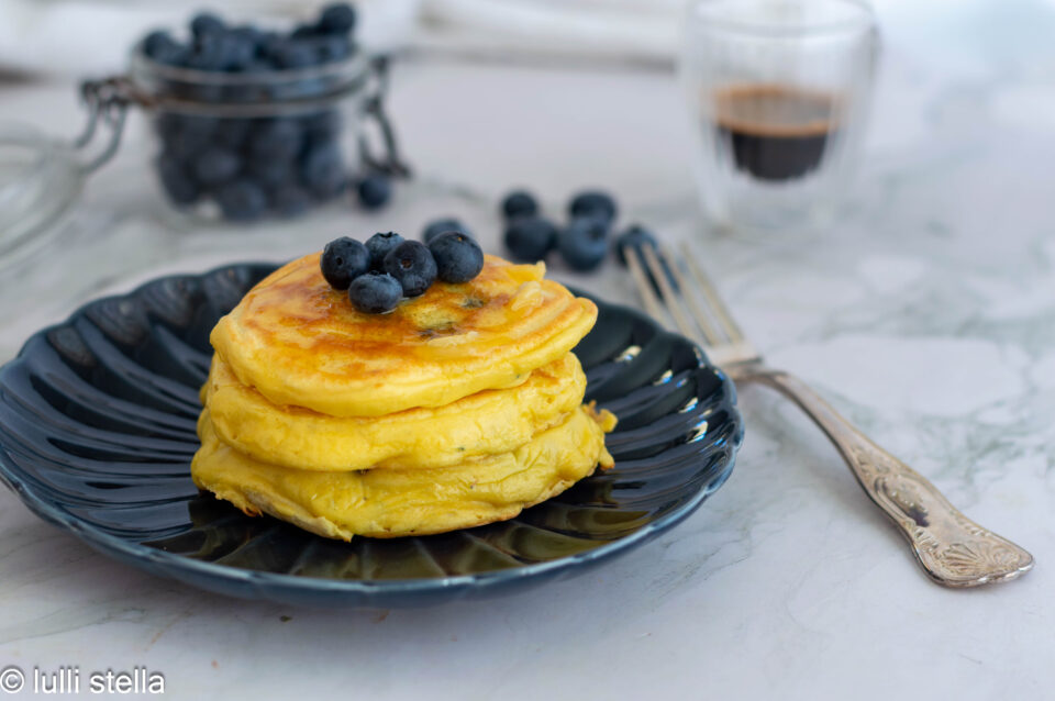 Pila di pancakes con farina di cocco e mirtilli appena preparati