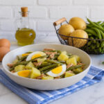 Piatto unico estivo con patate, fagiolini, tonno e uova sode condito con vinaigrette.