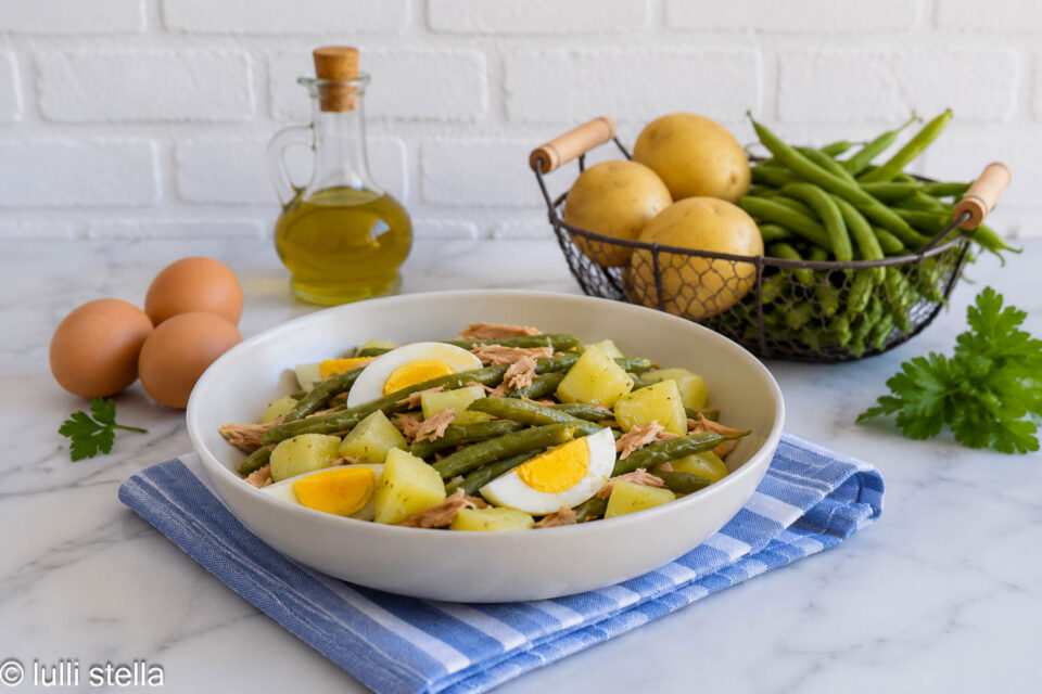 Piatto unico estivo con patate, fagiolini, tonno e uova sode condito con vinaigrette.