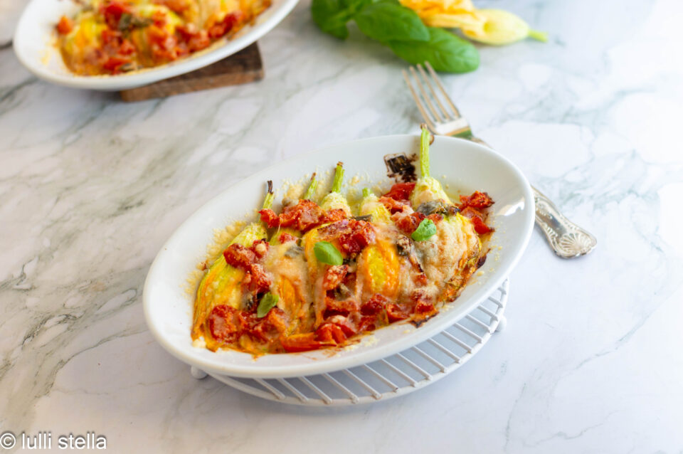 Dettaglio dei fiori di zucca ripieni con ricotta e parmigiano dorati in forno.