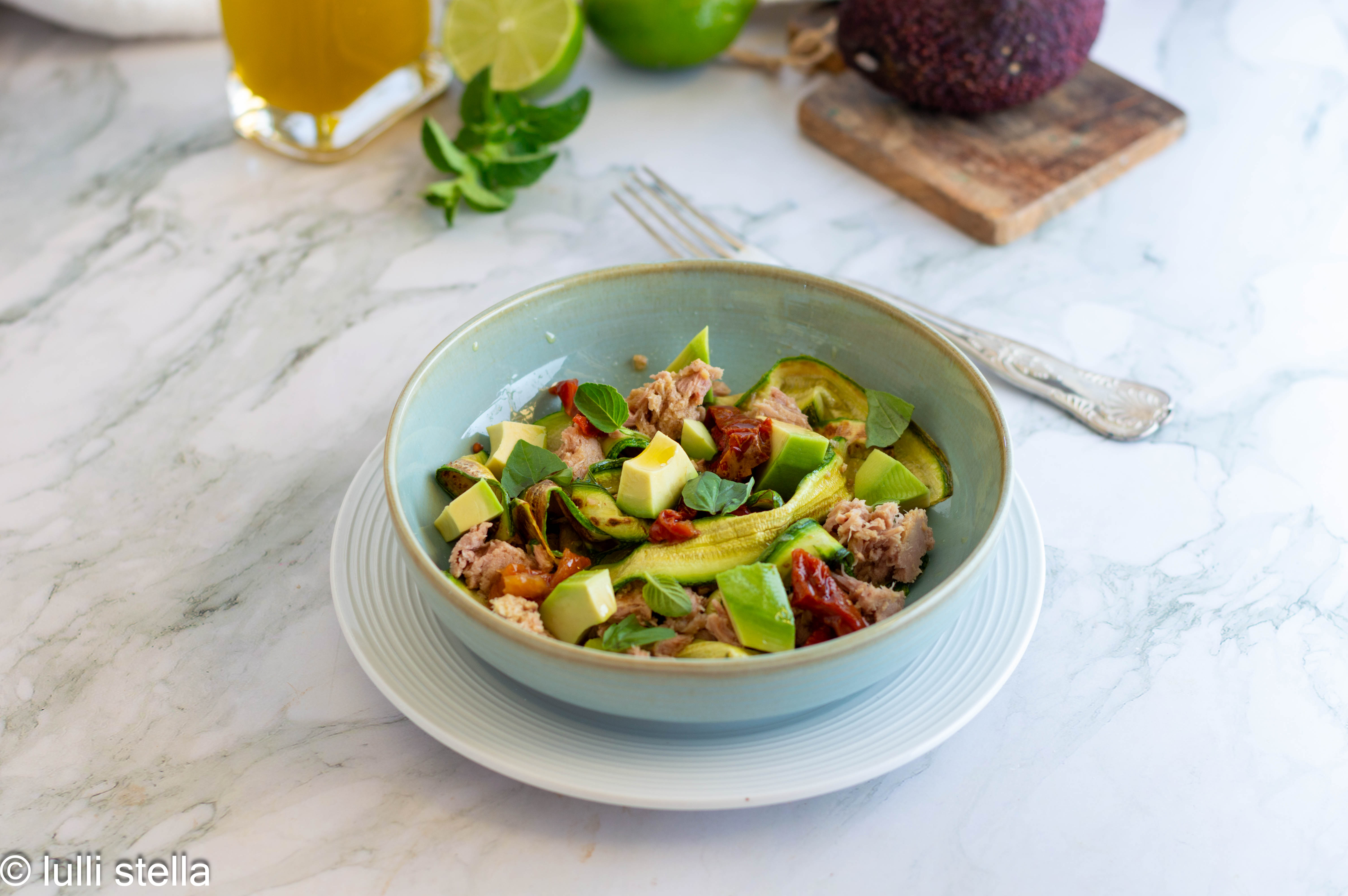 Insalata di zucchine grigliate con tonno e avocado servita nel piatto