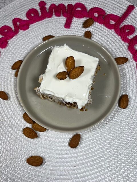 tortino avena e yogurt greco decorato con mandorle su piatto tondo grigio
