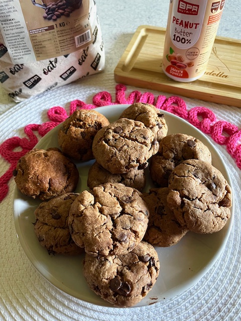 cookies al burro di arachidi su piatto tondo con prodotti su sfondo