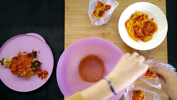 Divisione dei peperoni arrostiti al forno nei sacchetti gelo