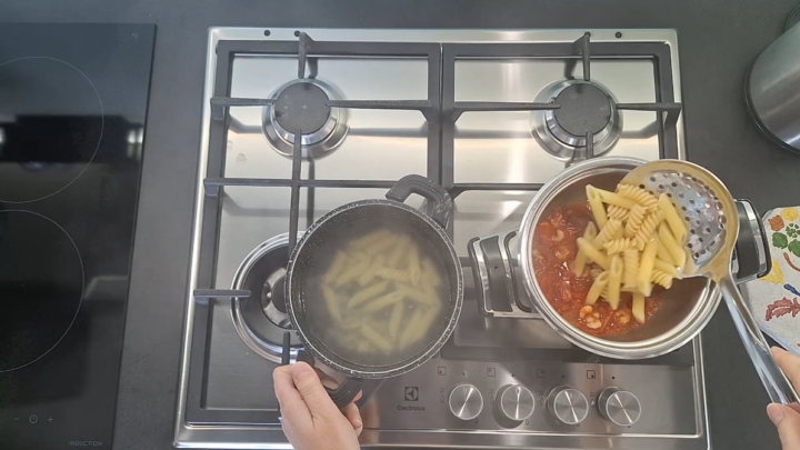 pasta nella pentole del sugo e gamberetti surgelati