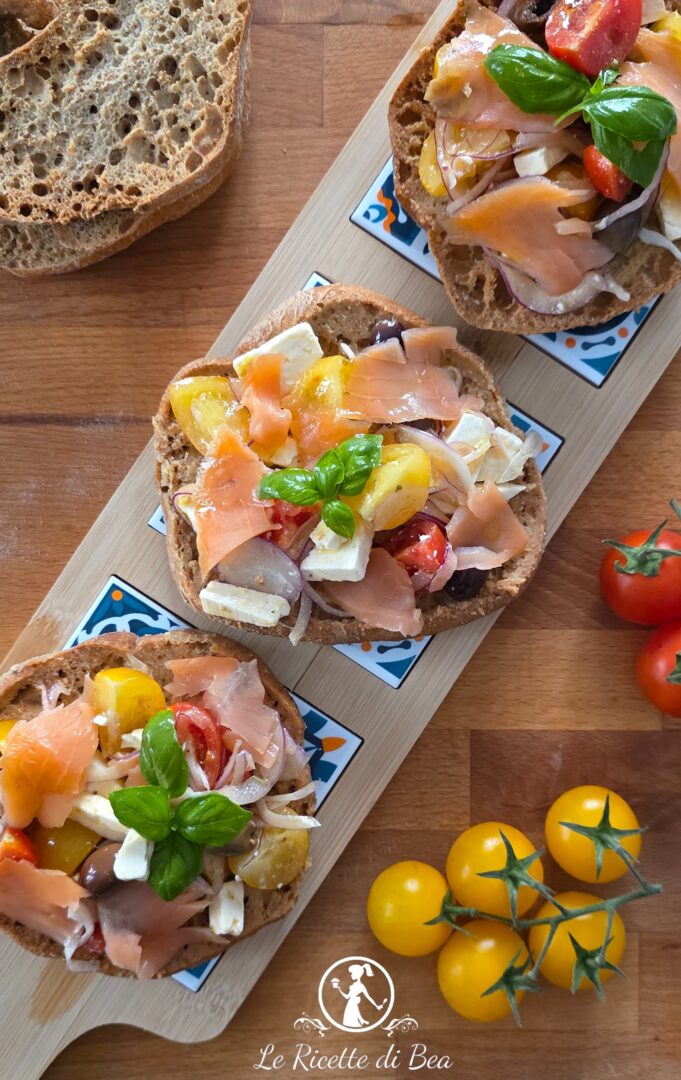 frisella pugliese con salmone, pomodori, cipolla e olive taggiasche