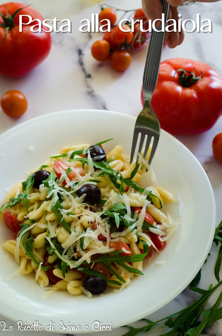 piatto di pasta con pomodori, rucola, olive nere