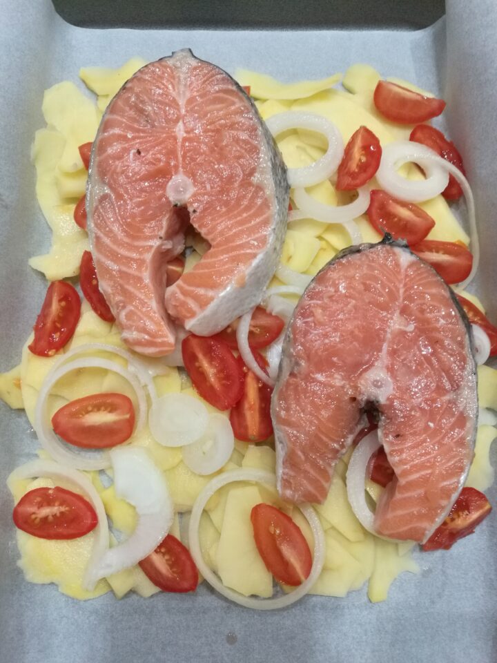 Tranci di salmone su letto di patate e pomodorini