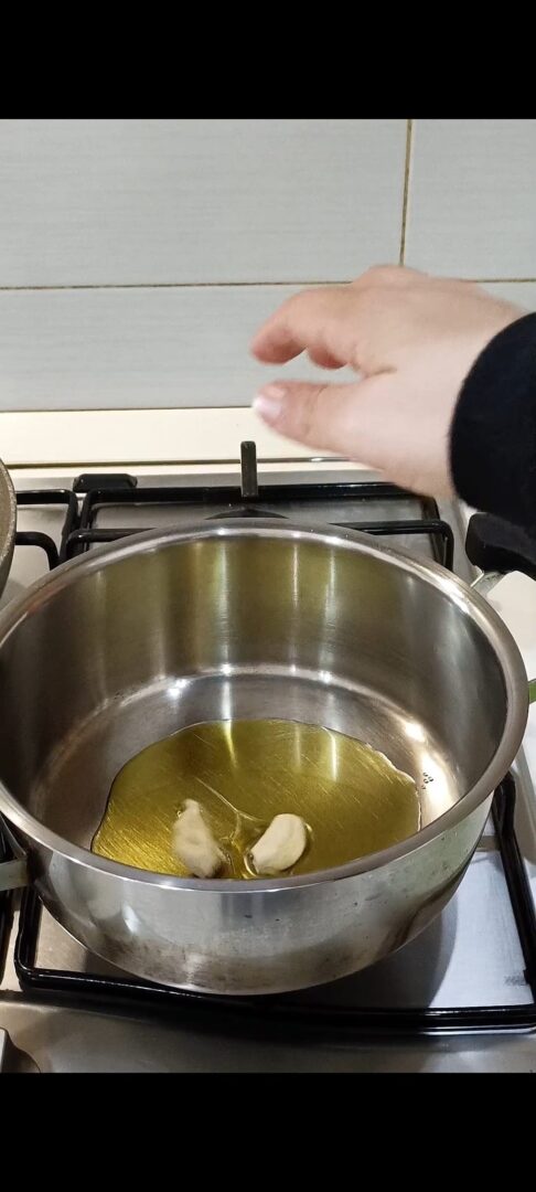 Versiamo l'olio d'oliva in pentola e aggiungiamo 2 spicchi d'aglio