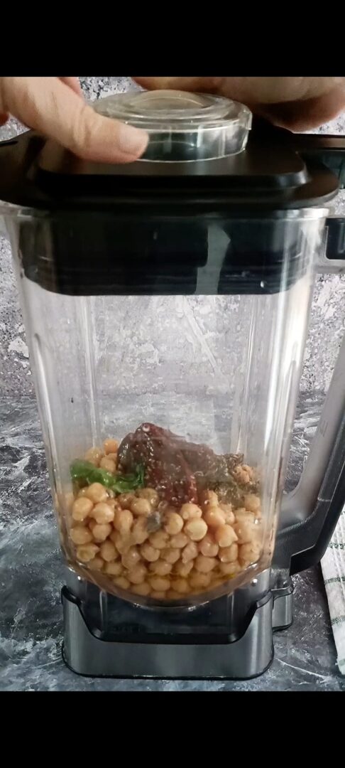 Ceci, succo di limone, tahina, pomodori secchi, basilico, olio, acqua, spezie, sale, pepe nel frullatore