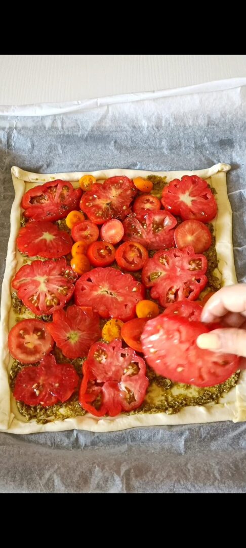 Disponiamo i pomodori sulla pasta sfoglia e il pesto