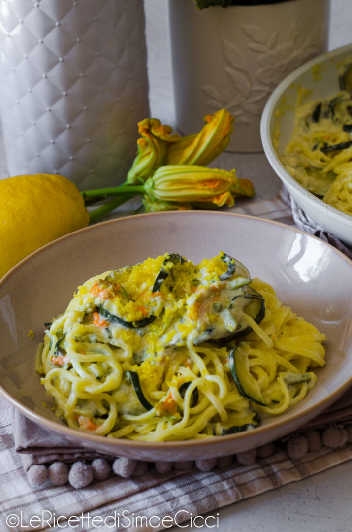 Pasta con zucchine, fiori di zucca, limone e panna: ricetta cremosa pronta in 20 minuti