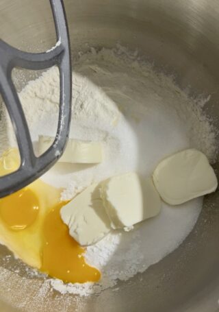 ingredienti pasta frolla nella planetaria con burro uova e farina