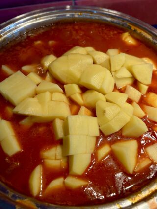 Preparazione spezzatino al sugo con patate