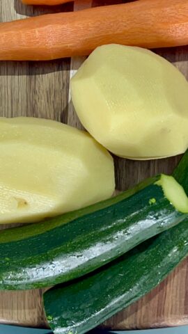 patate zucchine e carote crude sul tagliere prima della preparazione