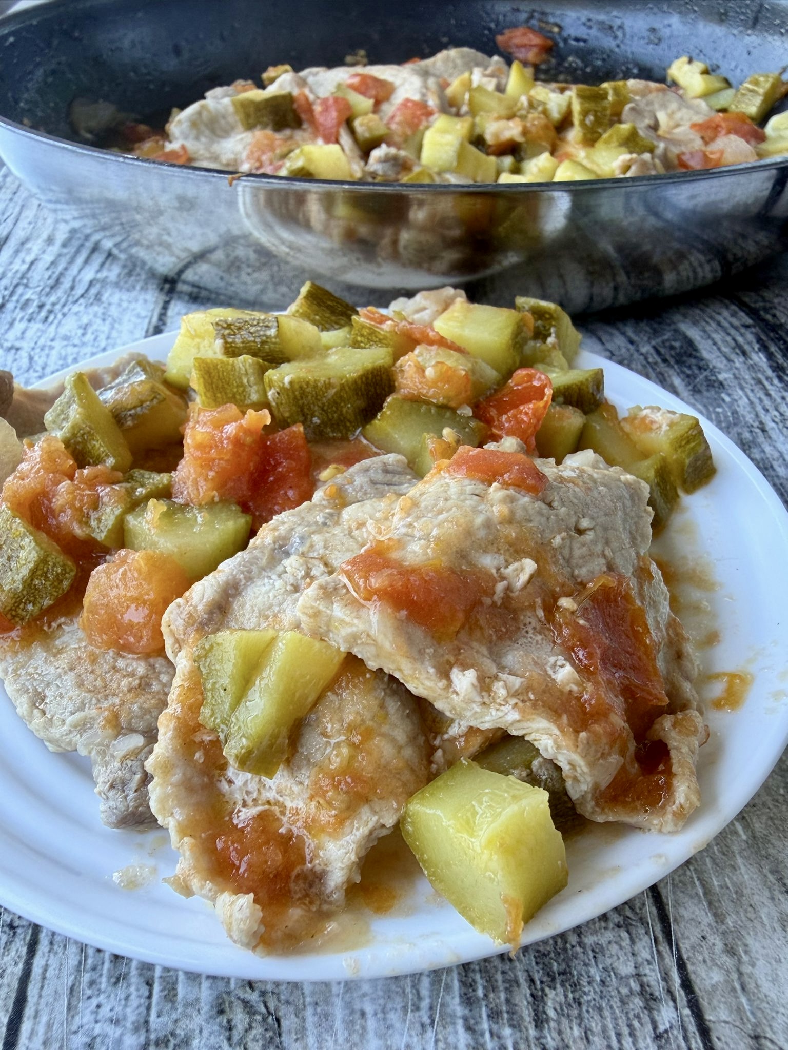Arista in padella con zucchine e pomodori pronta da servire