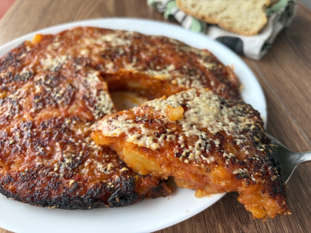 frittata di patate in padella al pomodoro con fetta servita