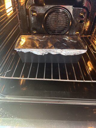 pasta alle melanzane nello stampo coperta con stagnola durante la cottura in forno