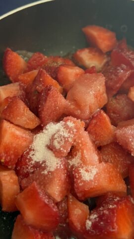 fragole a pezzetti con zucchero in padella per salsa pancake