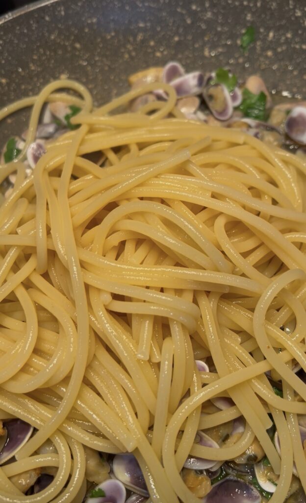 Spaghetti scolati al dente nel condimento di telline
