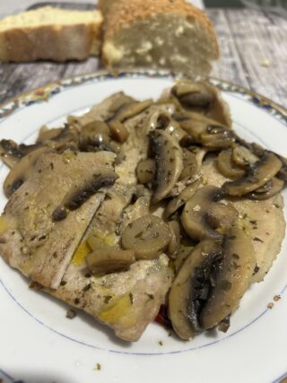 Arista ai funghi in padella pronta da servire con pane croccante