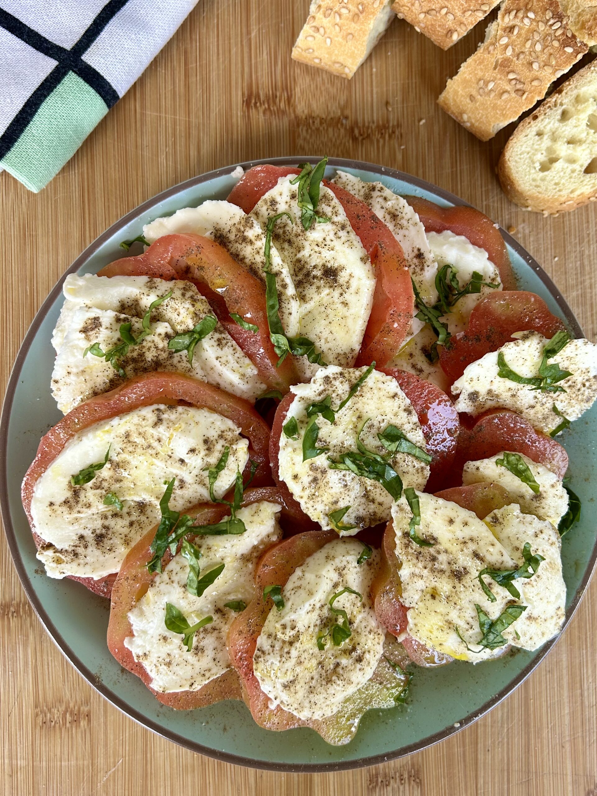 Caprese con pomodori cuore di bue e mozzarella fresca condita con olio extravergine, pepe e basilico