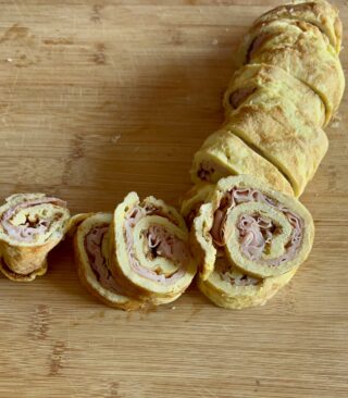 Taglio delle girelle di frittata con mortadella e formaggio
