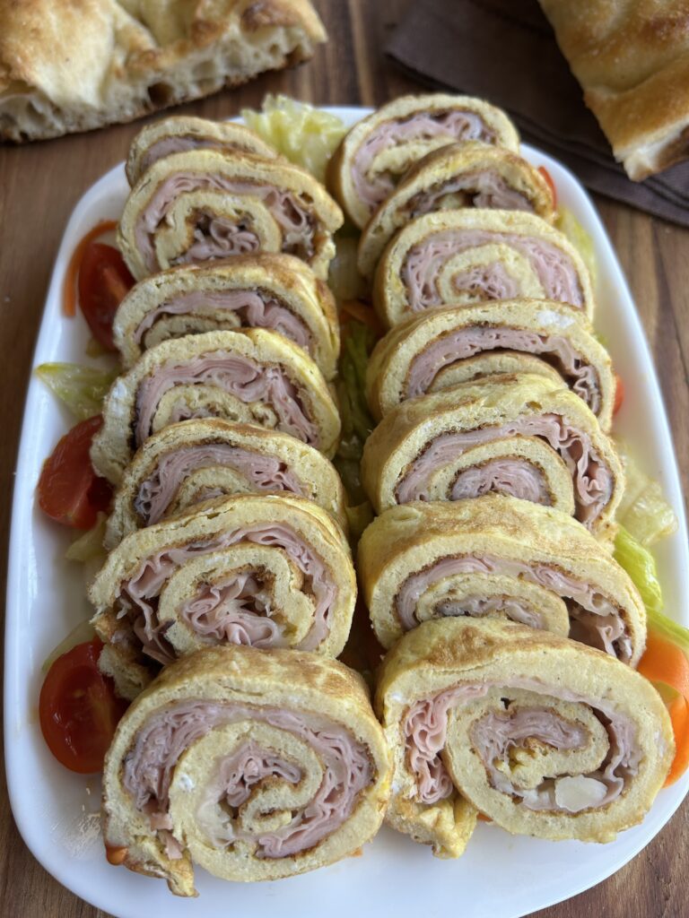 Girelle di frittata cotta in padella farcite con mortadella ed Edamer servite fredde