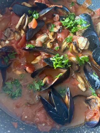 Sughetto di cozze, pomodori freschi e prezzemolo pronto per condire la pasta.