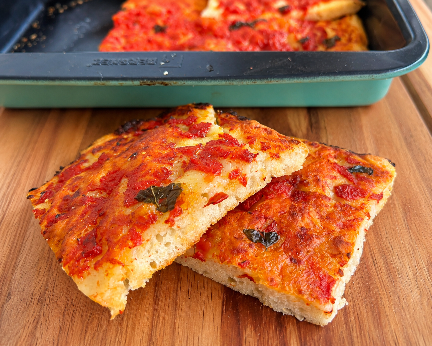 Trancio di focaccia al pomodoro con alveolatura soffice ottenuta utilizzando lievito madre avanzato
