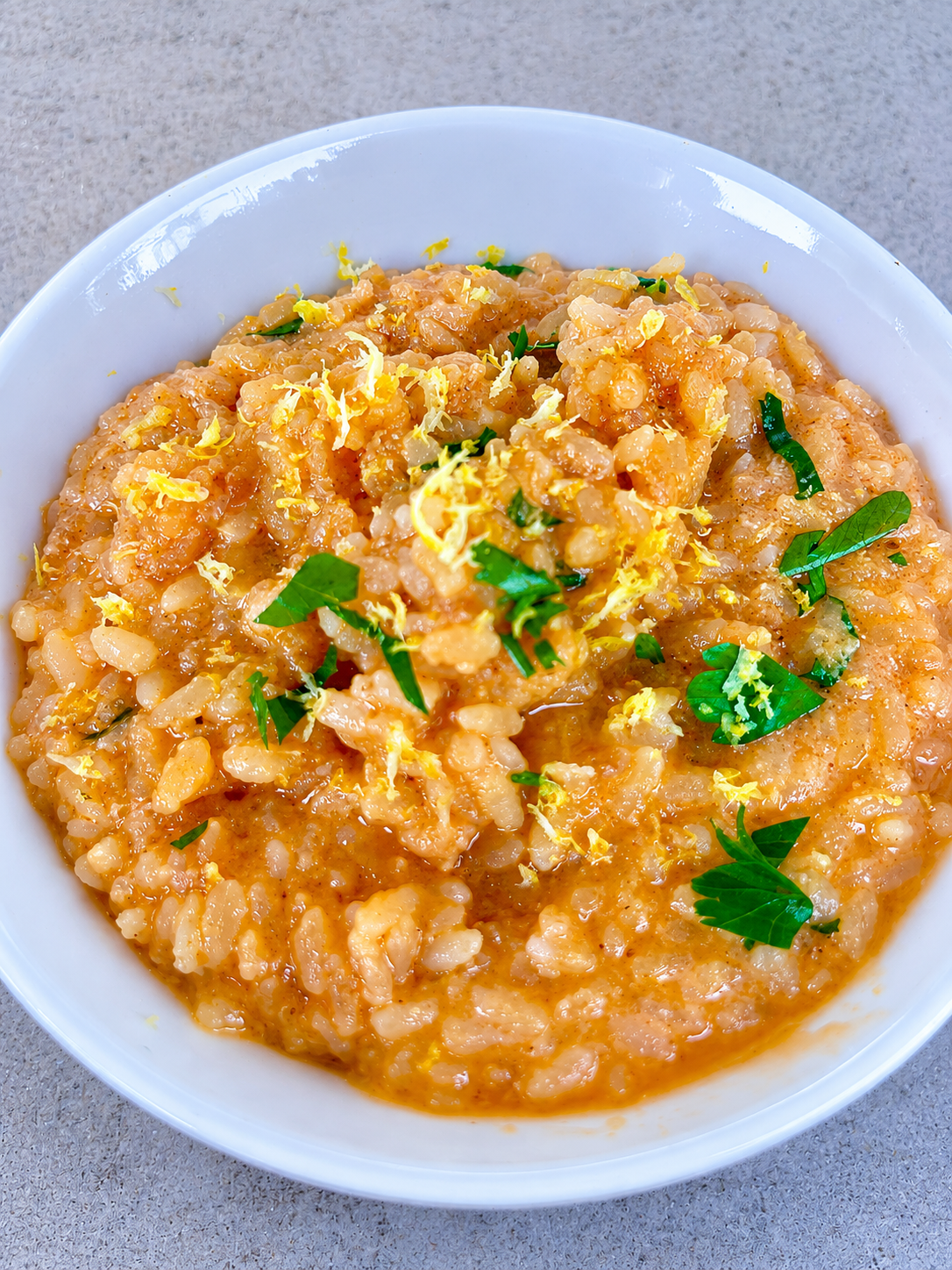 Risotto al salmone fresco e limone preparato con brodo fatto in casa e scorza di limone grattugiata