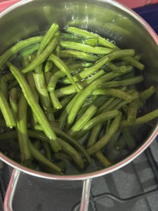 Fagiolini lessati scolati prima della cottura nel sugo di pomodoro.