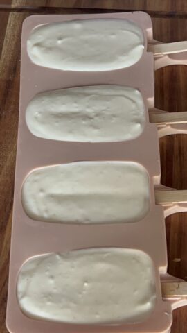 Stampi per gelati riempiti con il composto di panna e latte condensato