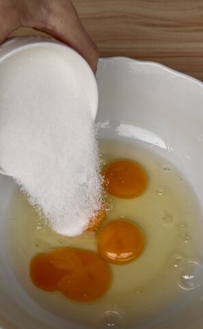 Uova e zucchero nella ciotola per preparare l'impasto della ciambella con okara