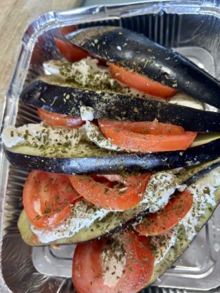 Melanzana con pomodoro, mozzarella, origano e olio pronta per il forno.