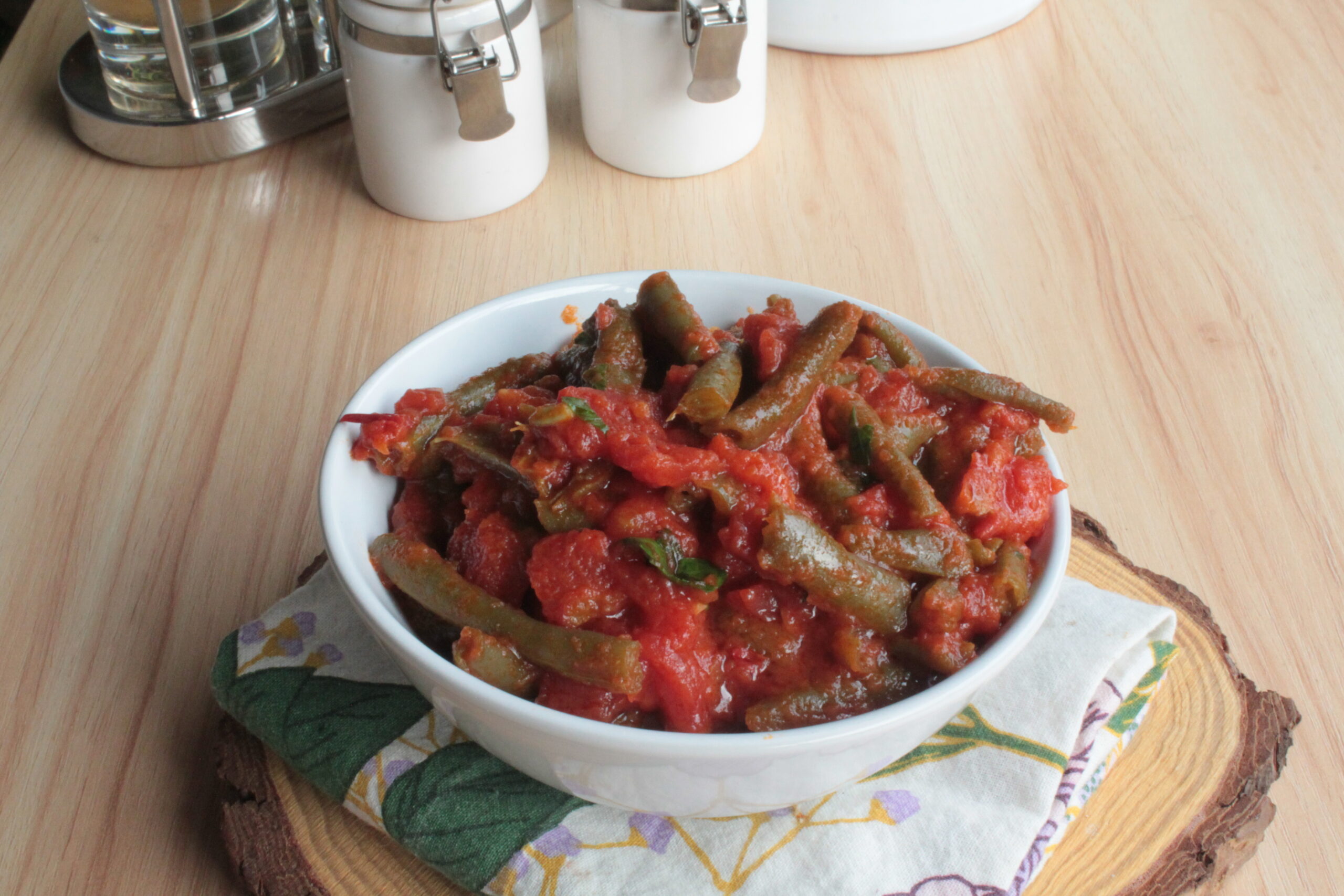 Fagiolini al pomodoro serviti in una ciotola bianca, contorno facile e saporito con aglio, olio e peperoncino.