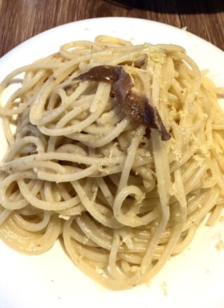 Piatto di pasta burro e alici con scorza di limone